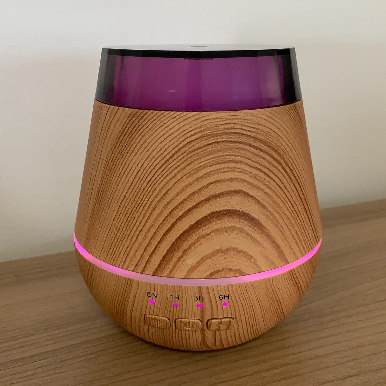 Wooden diffuser with purple accents on a wooden surface