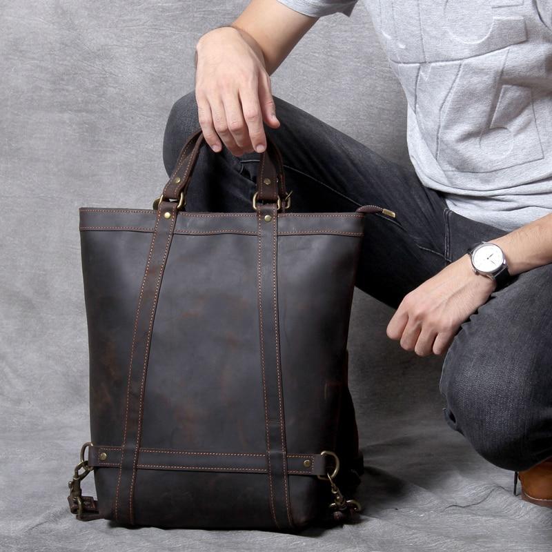 Person holding a brown leather bag on a gray background