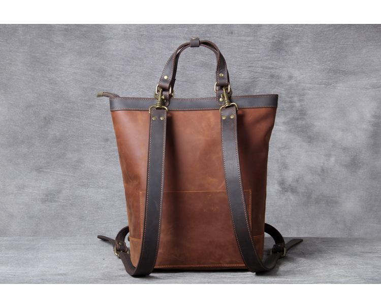 Brown leather backpack with black straps on a gray background