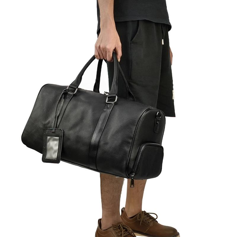 Person holding a black duffel bag on a white background